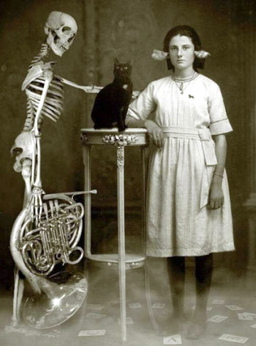 Girl with skeleton, french horn and black cat