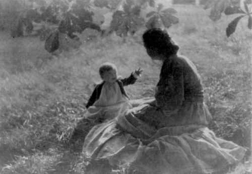 A photo of a young mother and child sitting on the lawn